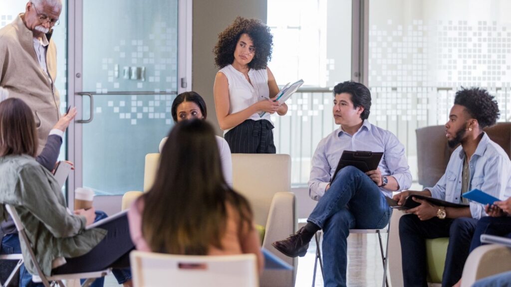 Meeting of seven people in an office with glass windows