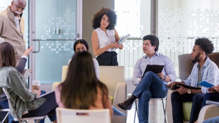 Meeting of seven people in an office with glass windows